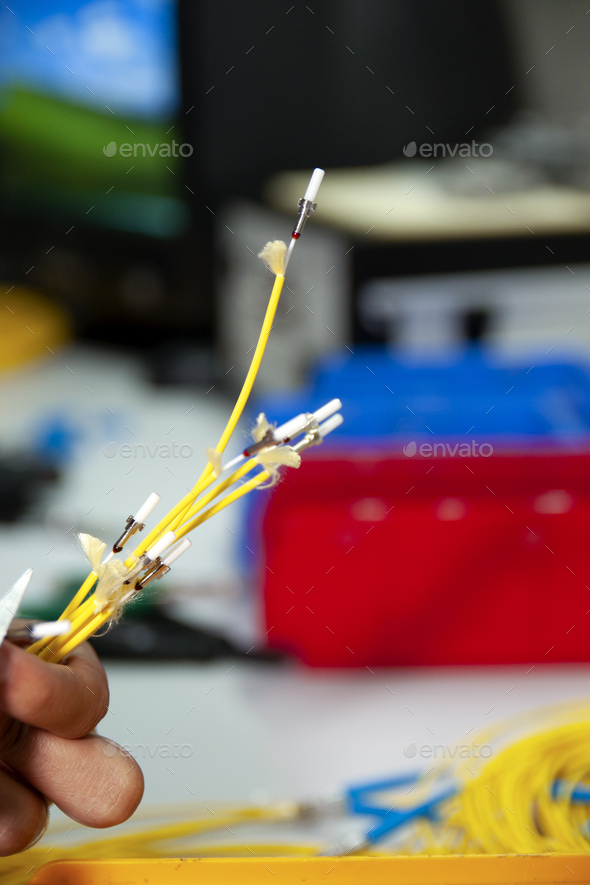 Technician cleaving an optical fiber, a crucial process for a good