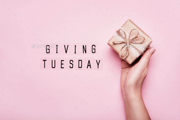 Giving Tuesday. Global day of charitable giving after Black Friday. Woman hand holding gift box