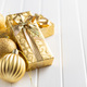 Two gold christmas gifts and christmas balls on white table. - PhotoDune Item for Sale