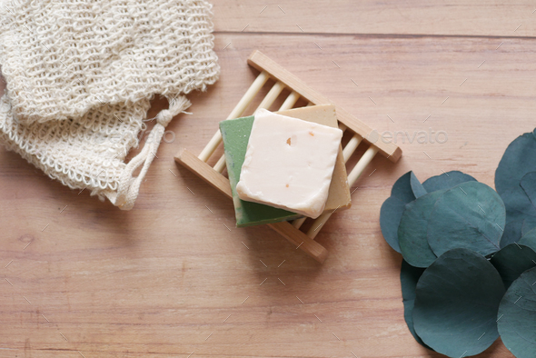 Homemade natural soap bar and empty soap bag on table