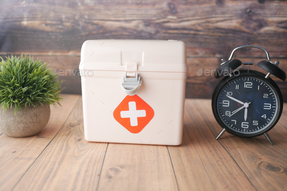  first aid kit box and a clock on table
