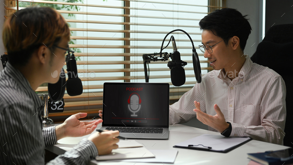 Male radio host using condenser microphone recording voice over radio interview.
