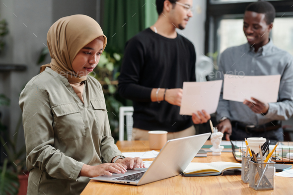 Young Muslim businesswoman organizing work in front of laptop - Stock Photo - Images