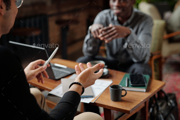Focus on hand of young businessman explaining his viewpoint to colleague - Stock Photo - Images