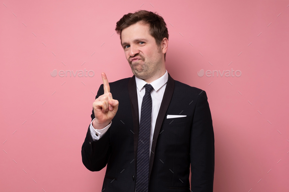 Mature man showing refusal gesture. It is not for me, leave me in piece, has angry expression.