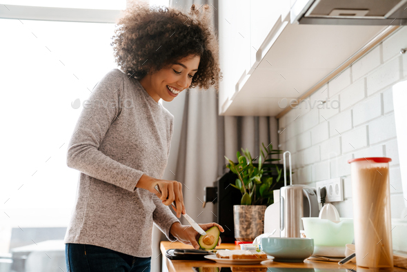 African american young woman making breakfast in morning at home Stock ...