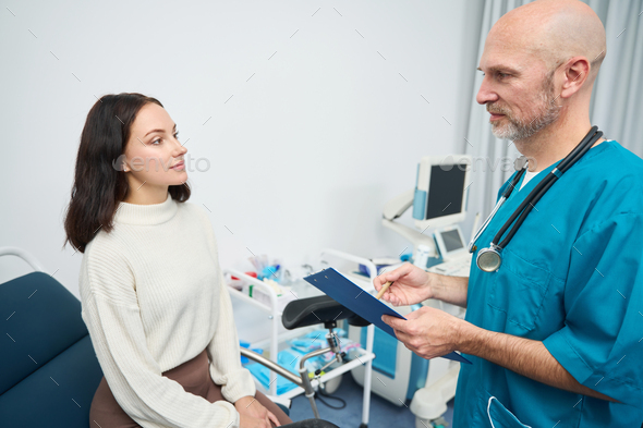 Woman at appointment with doctor is listening to him recommendations
