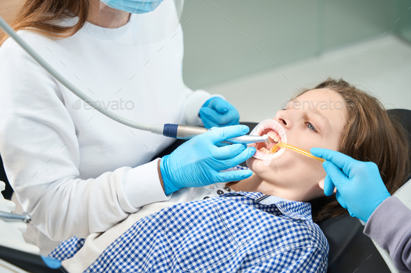 Young patient treats tooth at a dentist in medical institution