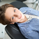 Handsome smiling teen boy is sitting in a dental chair - PhotoDune Item for Sale