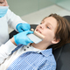 Woman doctor picks up color of tooth to teenager boy - PhotoDune Item for Sale