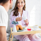 young happy family in pajamas having breakfast in bed together - PhotoDune Item for Sale
