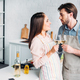 couple clinking with wineglasses in kitchen and looking at each other - PhotoDune Item for Sale