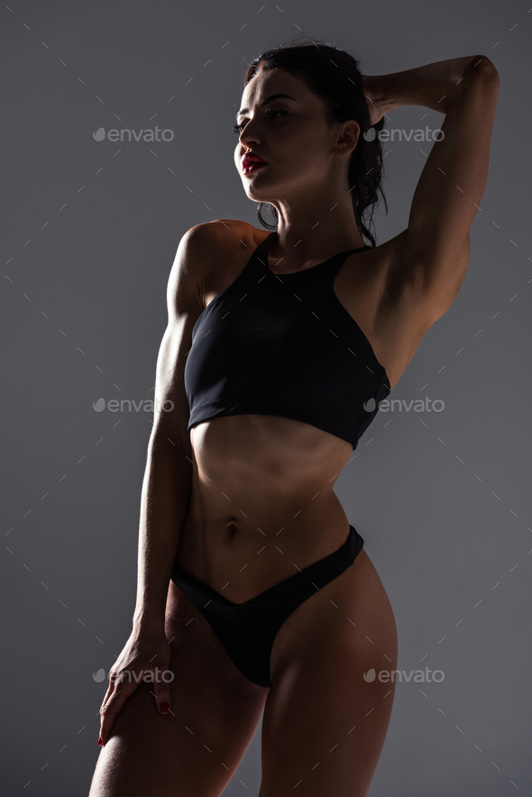 sexy woman in sport bra and panties posing isolated on grey Stock