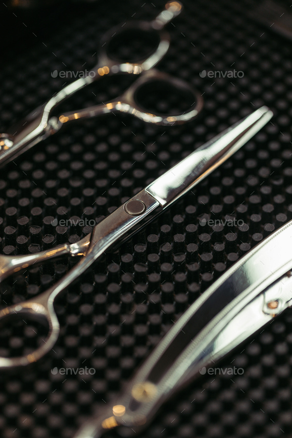 close-up view of various shiny professional scissors in hair salon