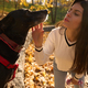 Cute young woman in park communicates with a black dog - PhotoDune Item for Sale