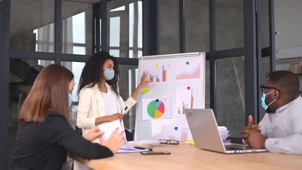 Diverse Work Team in Protective Medical Masks Working in Office During Pandemic alt