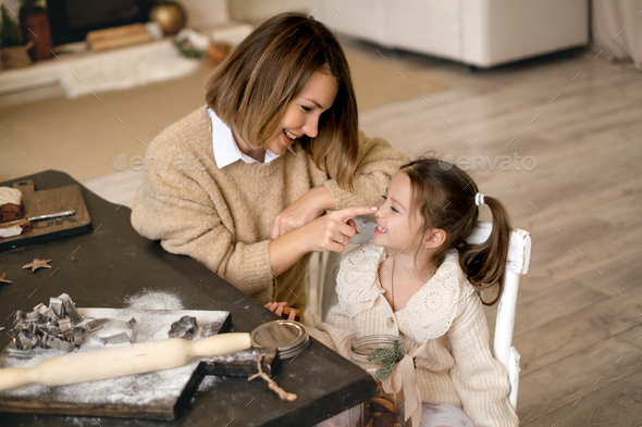 Mom and daughter cooking Christmas ginger cookies - Stock Photo - Images