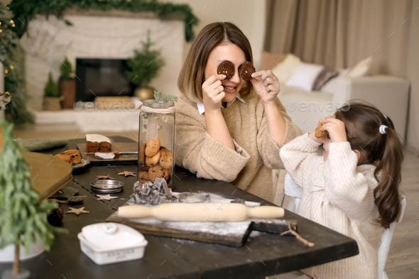 Mom and kid are having fun and playing with gingerbread - Stock Photo - Images