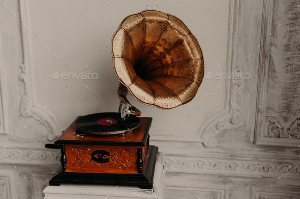 Old gramophone with horn speaker stands against anicent background ...