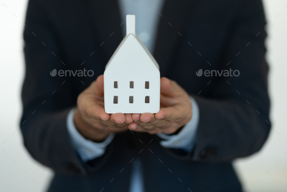 Holding the model house, real estate insurance and banking concept - Stock Photo - Images