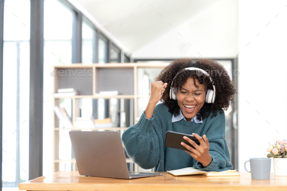 Photo of cheerful joyful mixed-race woman playing games and wearing wireless headphones at home Play - Stock Photo - Images