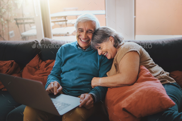 Retired couple watching funny video content on a laptop screen