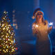 Woman standing near christmas tree with sparklers in hands - PhotoDune Item for Sale