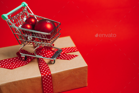 Christmas sale Shopping web banner with mini trolley cart with gift box and red xmas ornaments - Stock Photo - Images