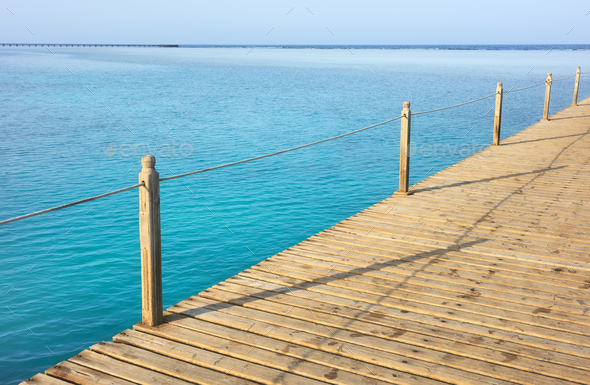 Wooden pier with rope railing, selective focus. Stock Photo by