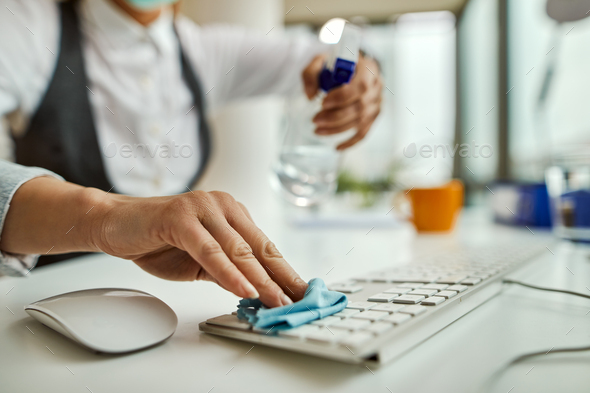 Close-up of businesswoman cleaning computer keyboard.