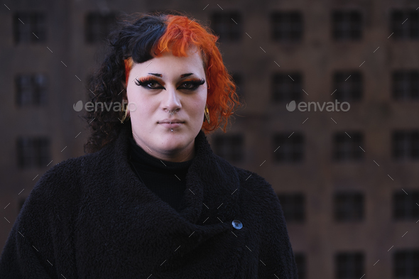Portrait of a young transgender woman with dyed orange hair. - Stock Photo - Images