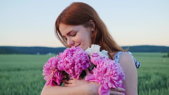 Adorable Beautiful Red Haired with Freckles Holding Pink Flowers in the Field alt