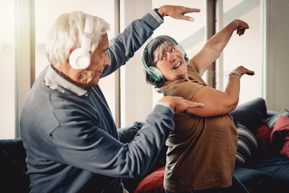 A Couple of perky grannies doing physical activity and having fun dancing in the living room