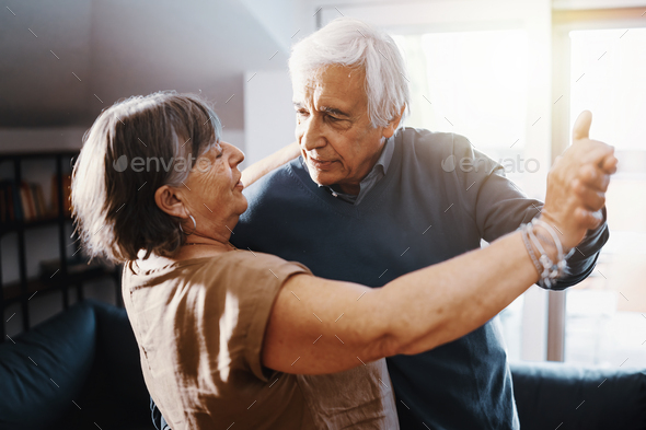 Retired active couple dancing in the living room