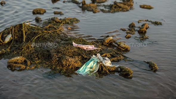 Coronavirus waste polluting the environment. Disposable masks trash sea