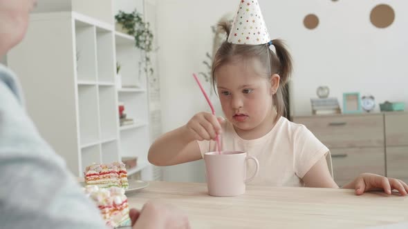 Woman and Handicapped Kid Eating Birthday Cake alt