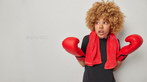 Woman boxer in athletic attire and gloves, showcasing her punch