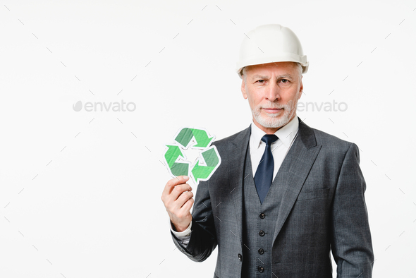 Middle-aged engineer architect in hardhat holding recycling logo sign for zero waste lifestyle