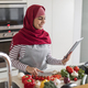 Happy muslim woman enjoying cooking at home, using digital tablet - PhotoDune Item for Sale