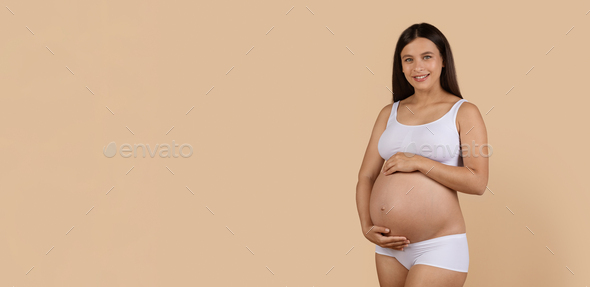 Portrait Of Beautiful Smiling Pregnant Lady In White Underwear Embracing Belly - Stock Photo - Images