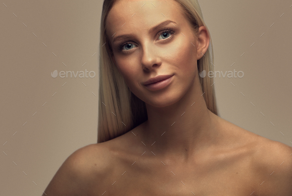 Portrait of a smiling beautiful woman with blonde hair in studio - Stock Photo - Images