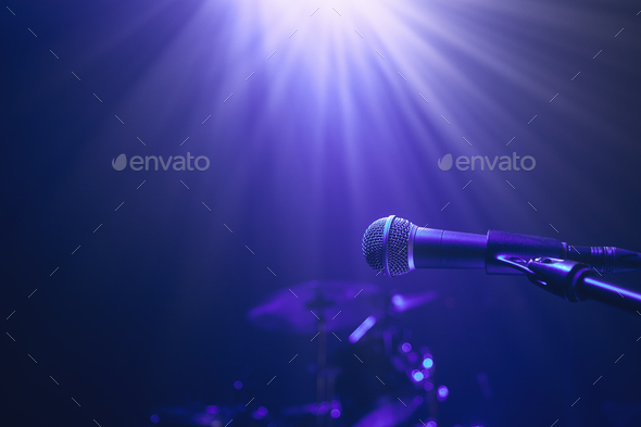 Illuminated microphone against drum kit on stage - Stock Photo - Images