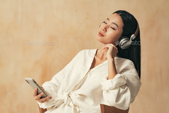 Peaceful asian woman relaxing with closed eyes, listening to