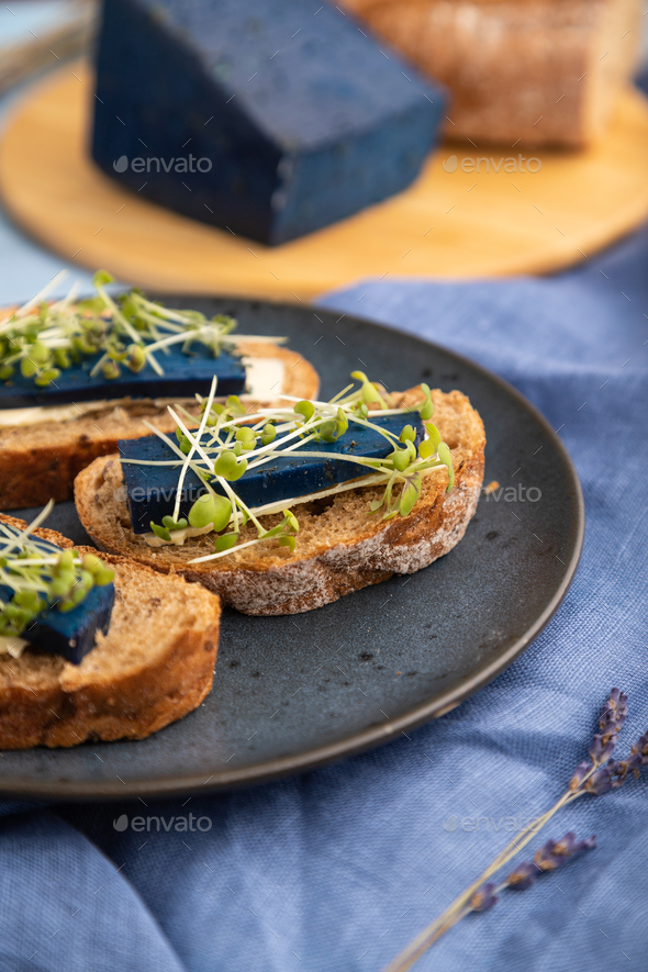 Bread sandwiches with blue cheese and mustard microgreen on blue, side view, selective focus. - Stock Photo - Images