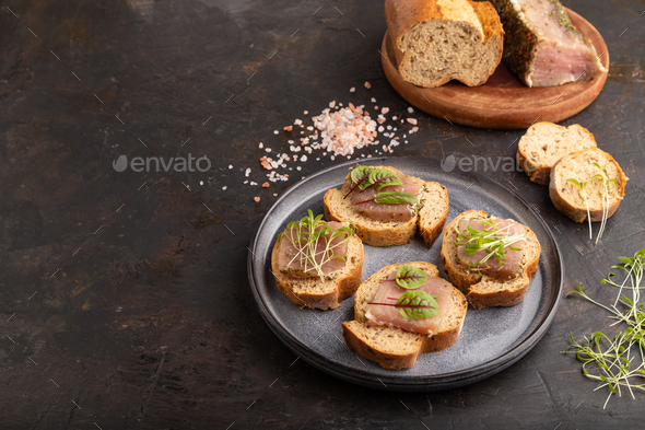 Bread sandwiches with jerky meat, sorrel and cilantro microgreen on black. side view, copy space. - Stock Photo - Images