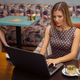 Young beautiful smiling brunette woman works on laptop in cafe - PhotoDune Item for Sale