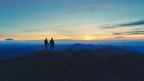 The couple standing on the mountain on the sunset background Stock ...