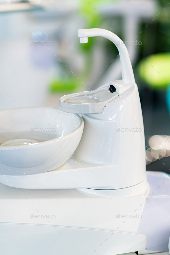 Dentist chair, sink and console with equipment Stock Photo by microgen