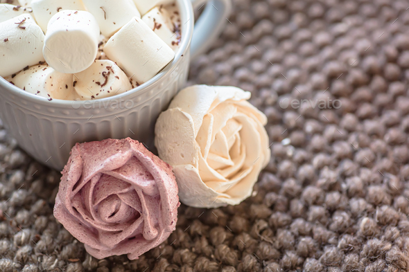 Marshmallow looks like rose close-up. cup with small marshmallows sprinkled with grated chocolate on