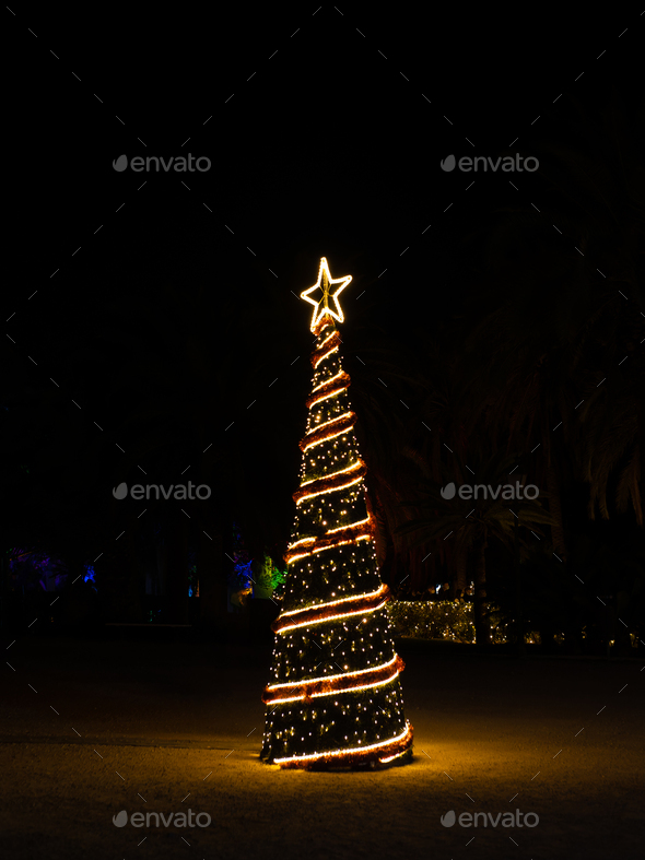 Christmas tree with light garlands at night - Stock Photo - Images